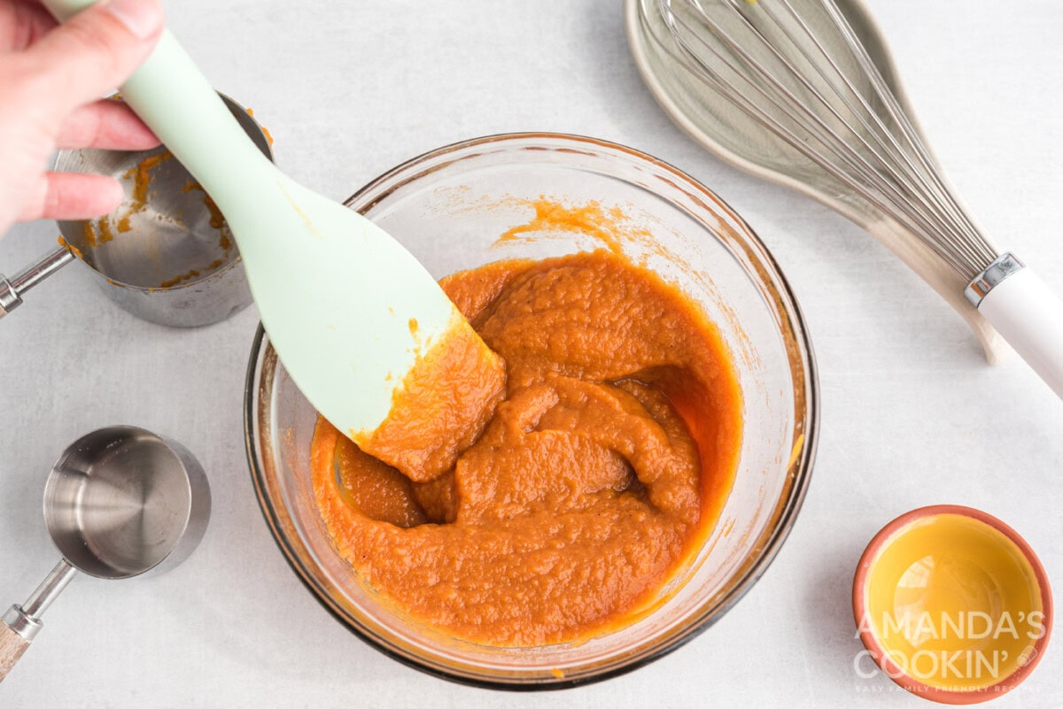 pumpkin pie filling in a mixing bowl with spoon