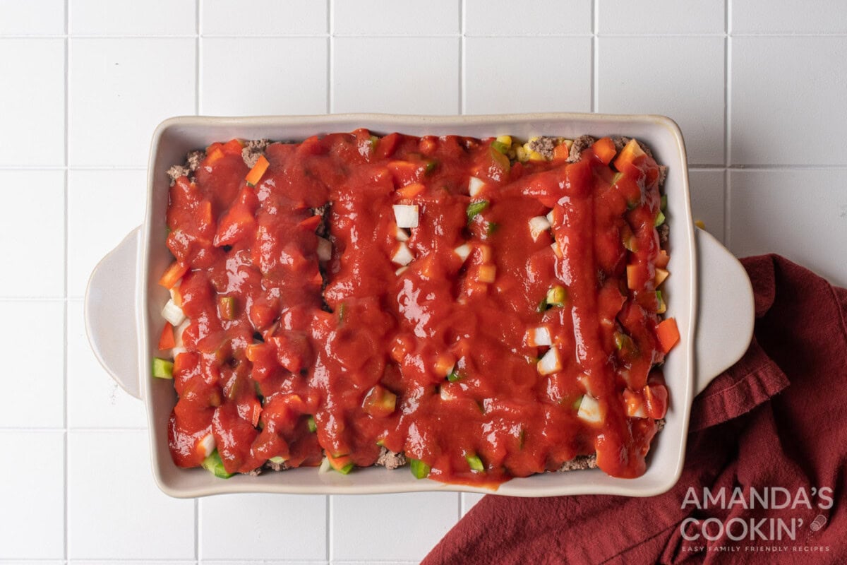 pasta sauce over veggies in a baking dish