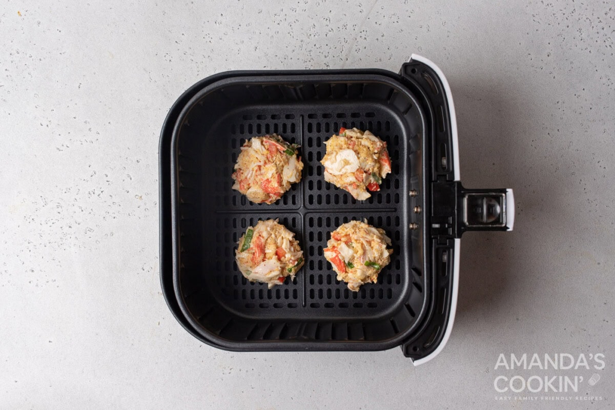 crab cake patties in an air fryer basket