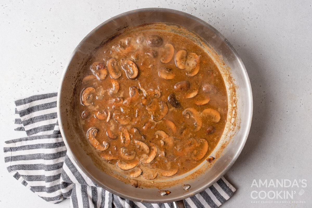 chicken stock added to skillet of mushrooms and onions