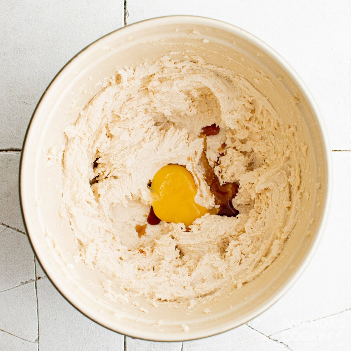 egg yolk in mixing bowl with butter and sugar mixture
