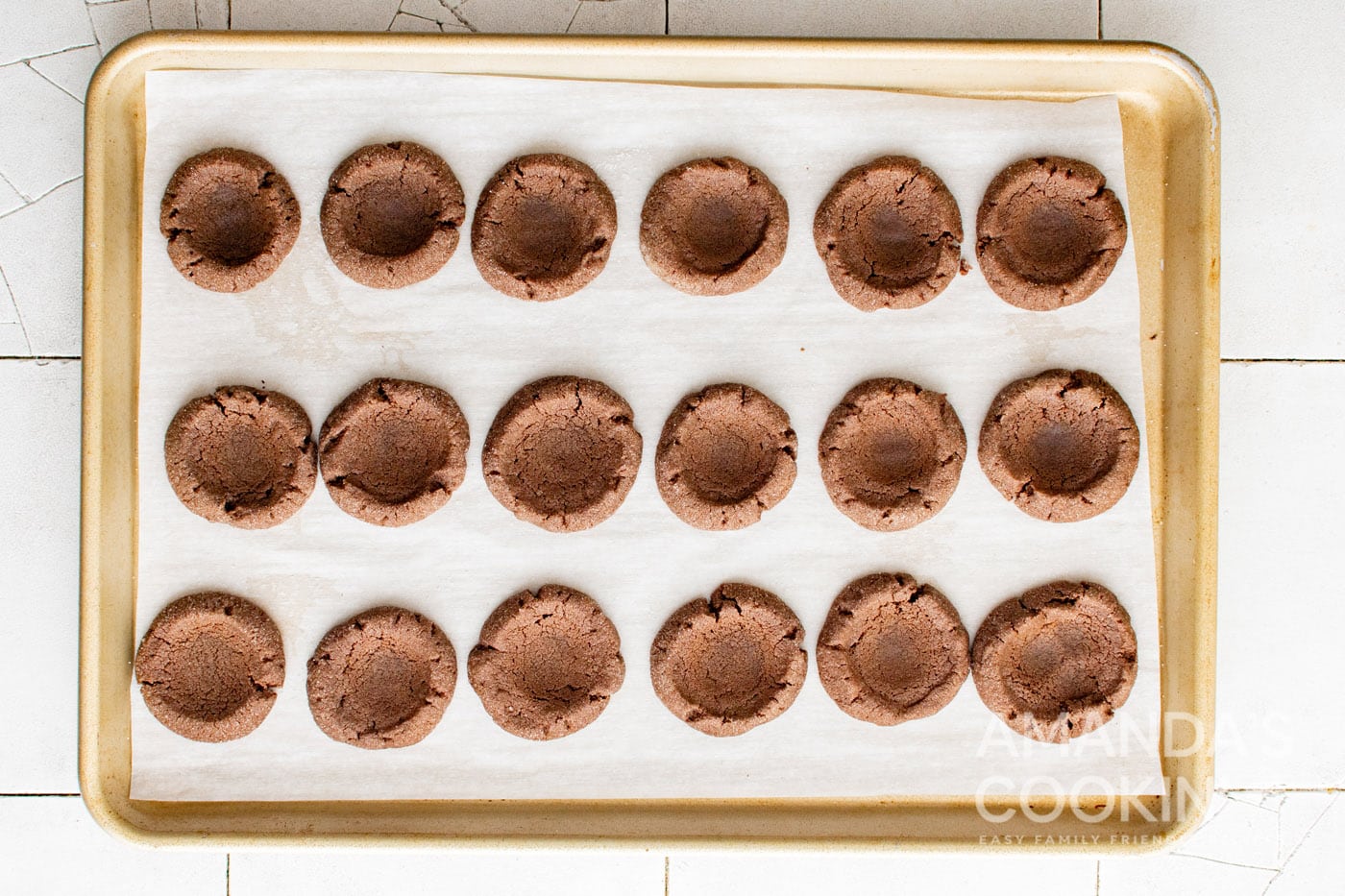 baked chocolate thumbprint cookies on cookie sheet