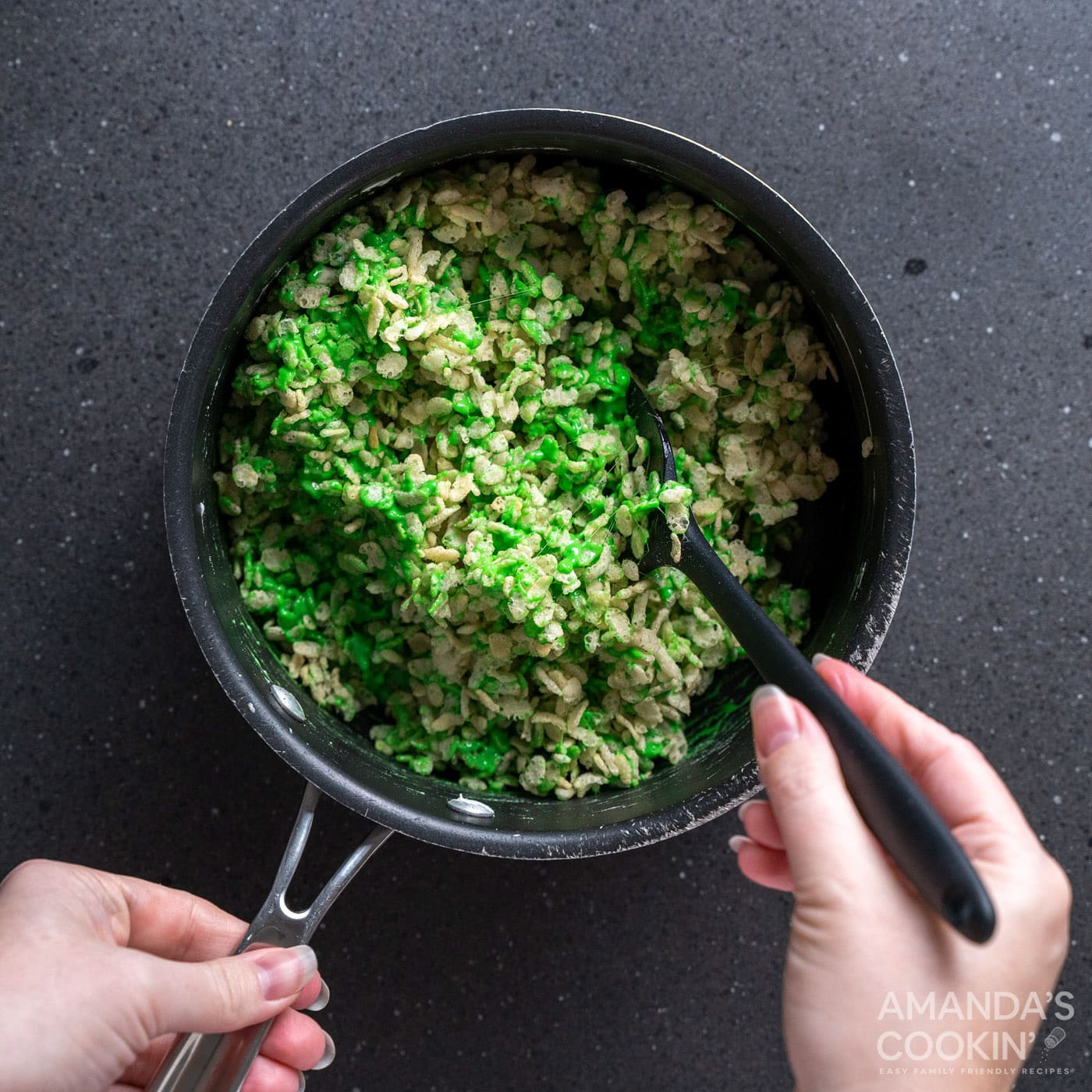 stirring rice krispie cereal into green marshmallows
