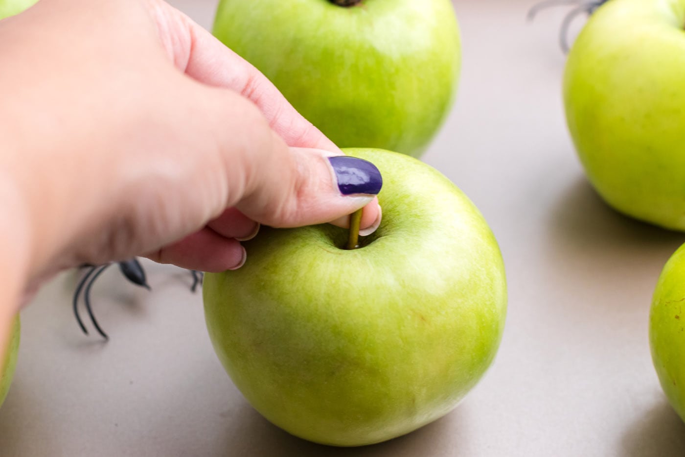 hand removing stem of green apple
