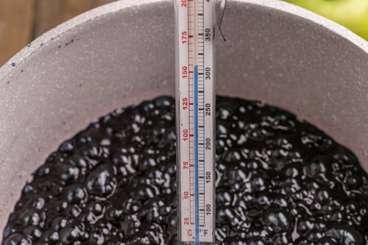 candy thermometer in candy apple coating mixture