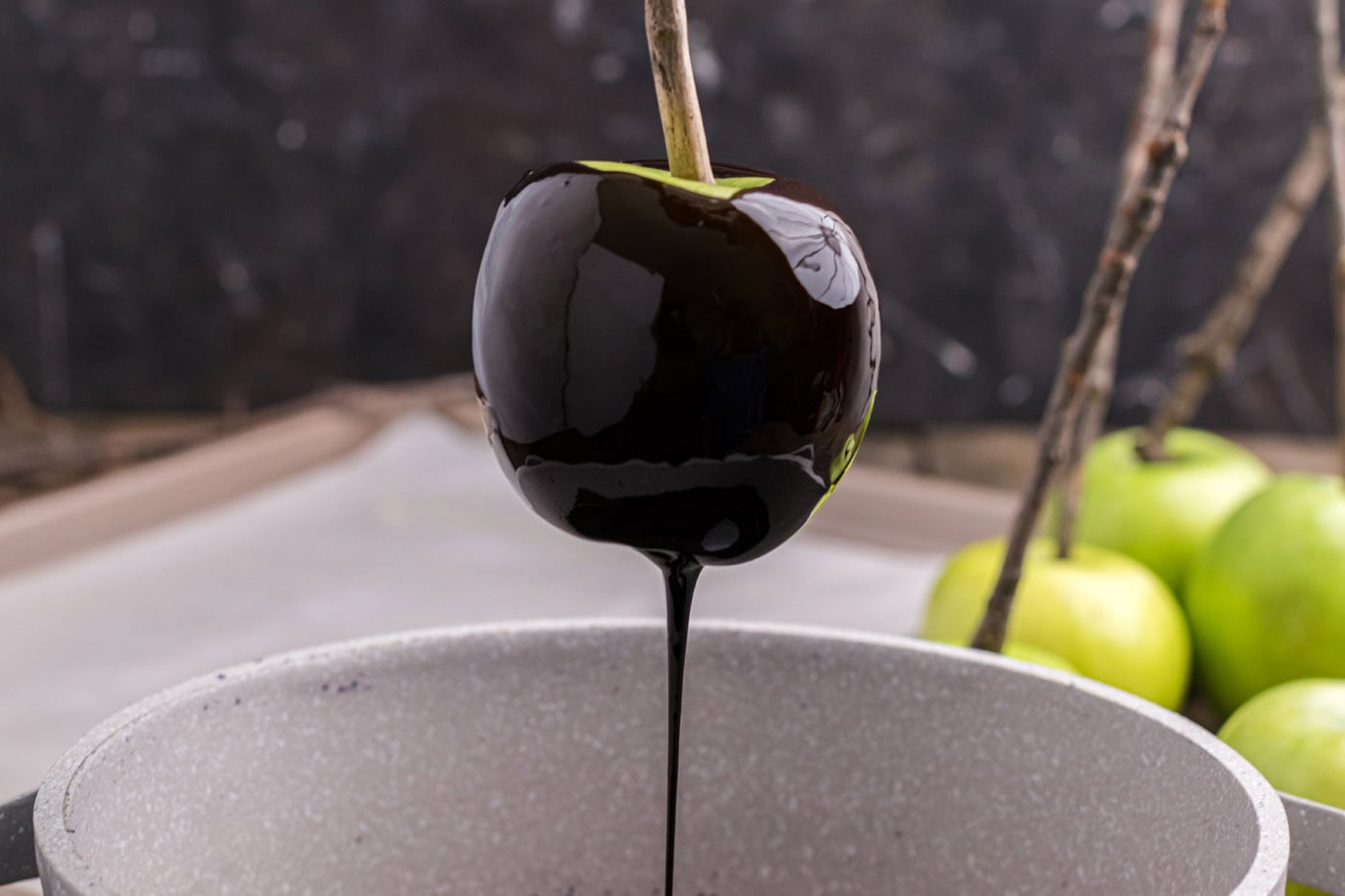 black candy coating dripping off an apple
