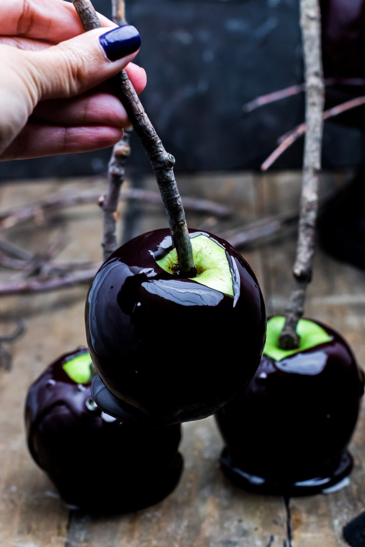 lifting a black Halloween Caramel Apple