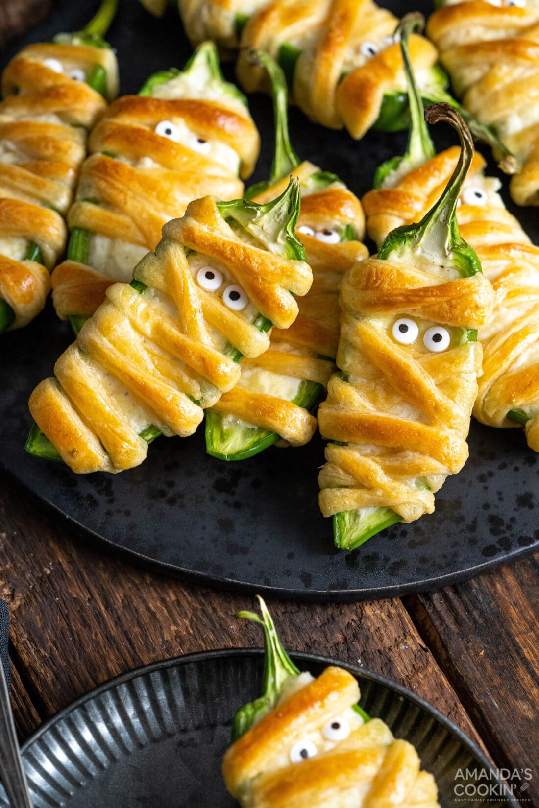 Jalapeno Popper Mummies on a black plate