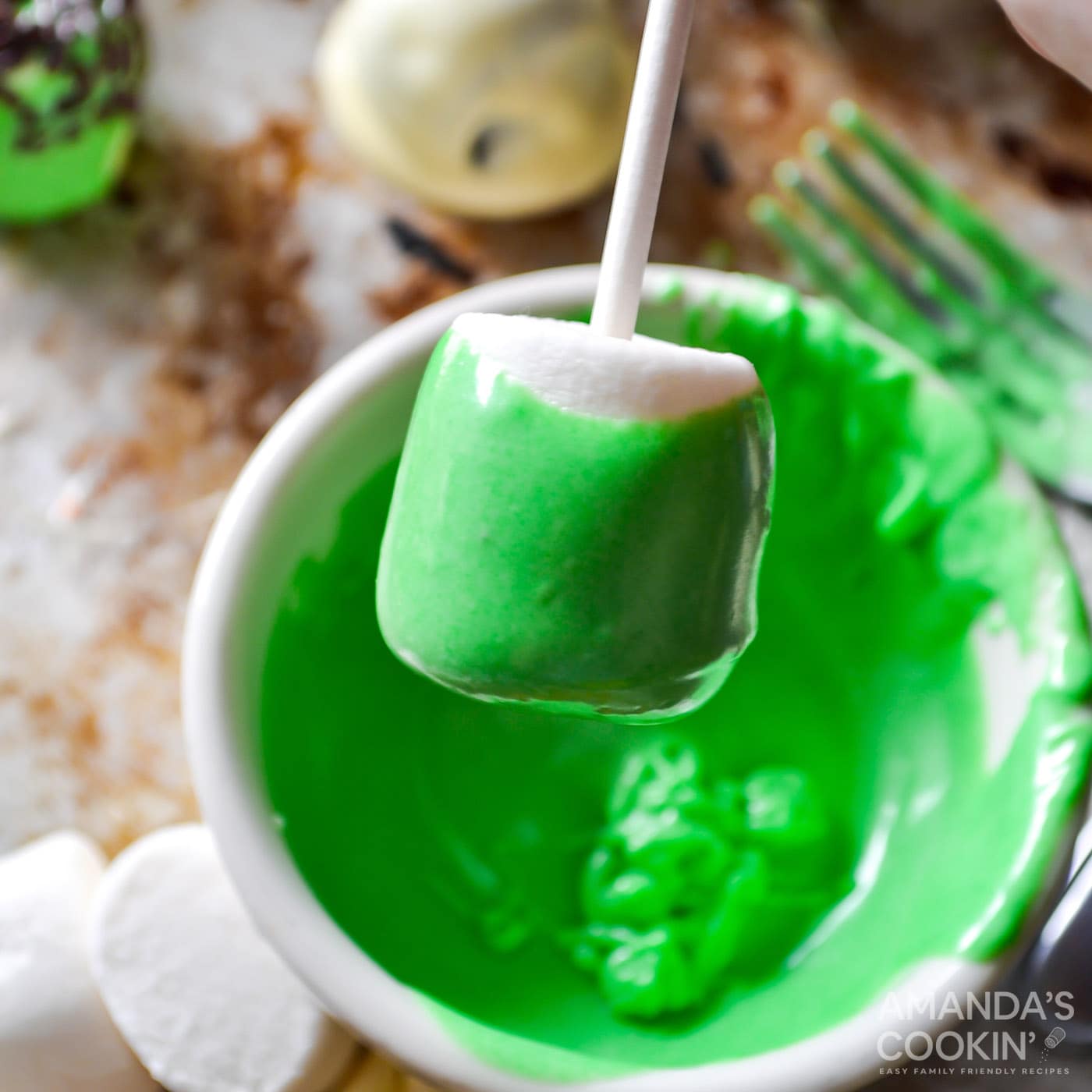 dipping marshmallow into green chocolate
