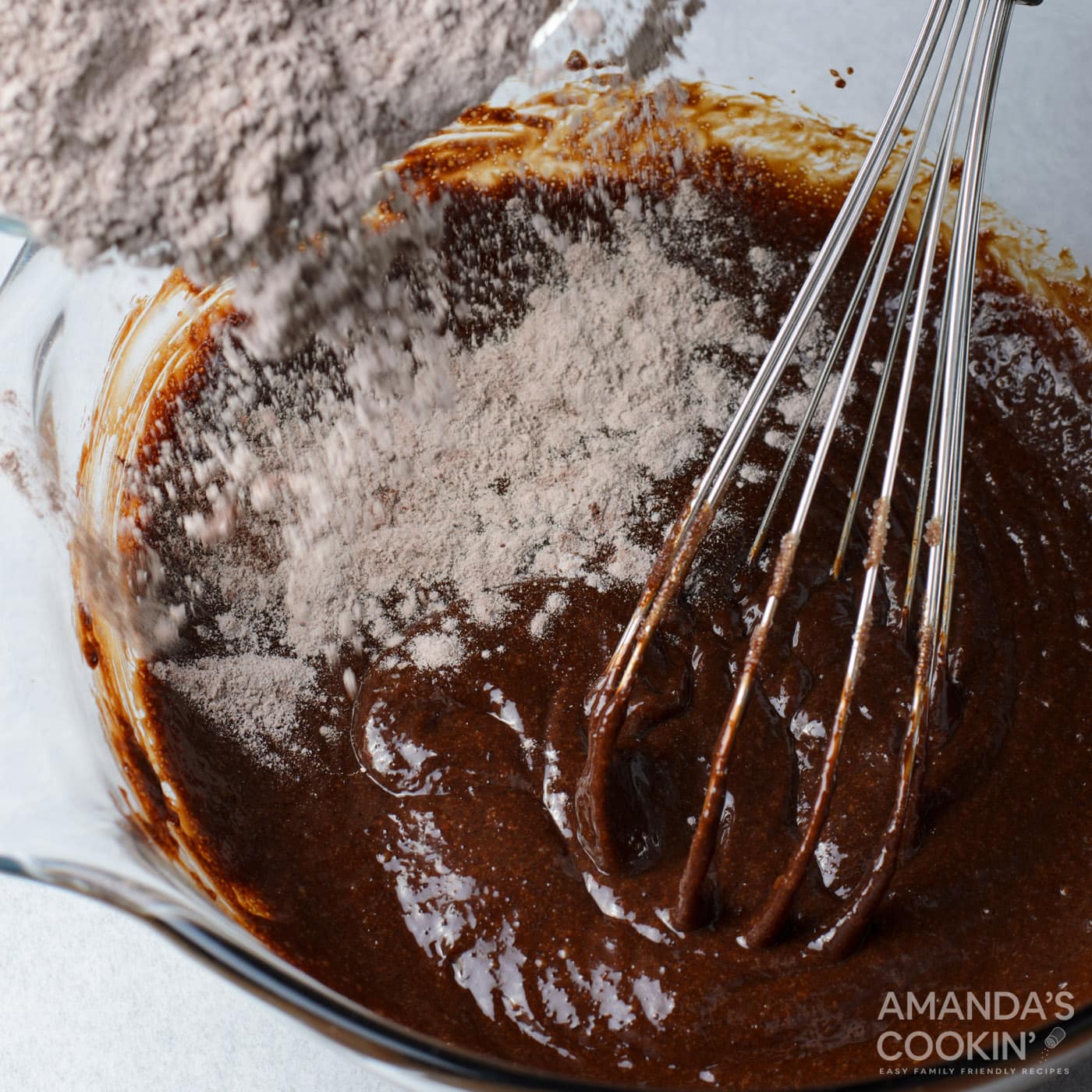 dry ingredients added to brownie batter with a whisk