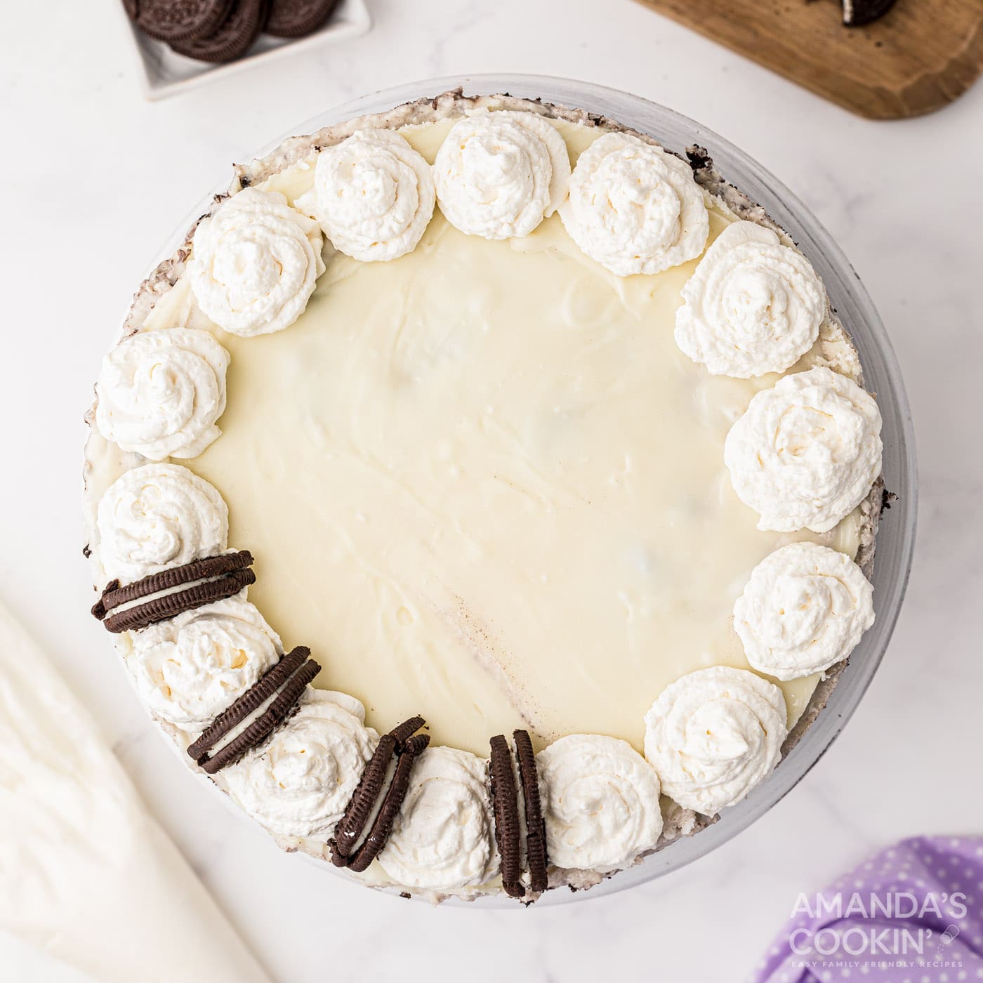 Oreo cookies in the middle of whipped cream swirls on cheesecake
