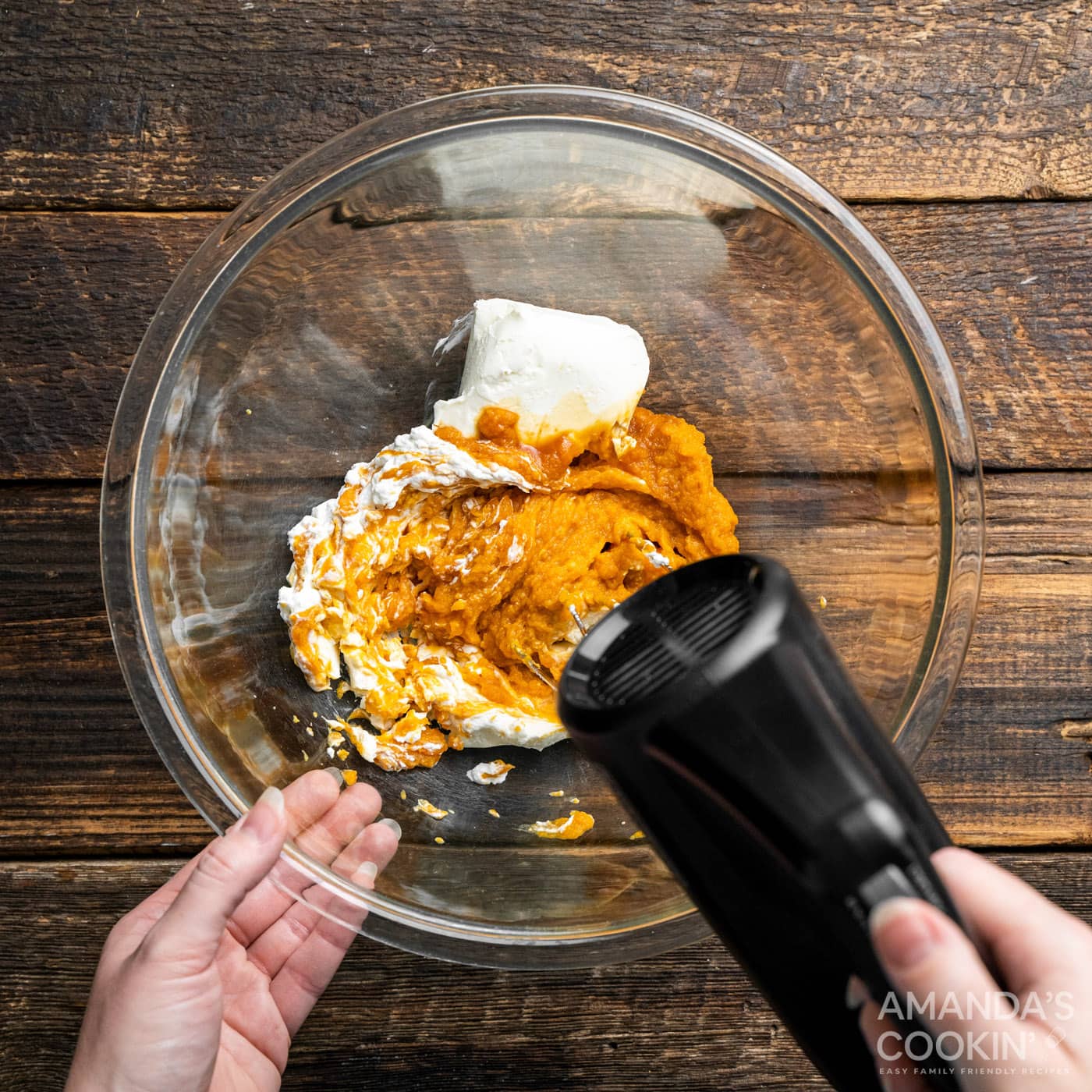 hand mixer beating together pumpkin puree and cream cheese