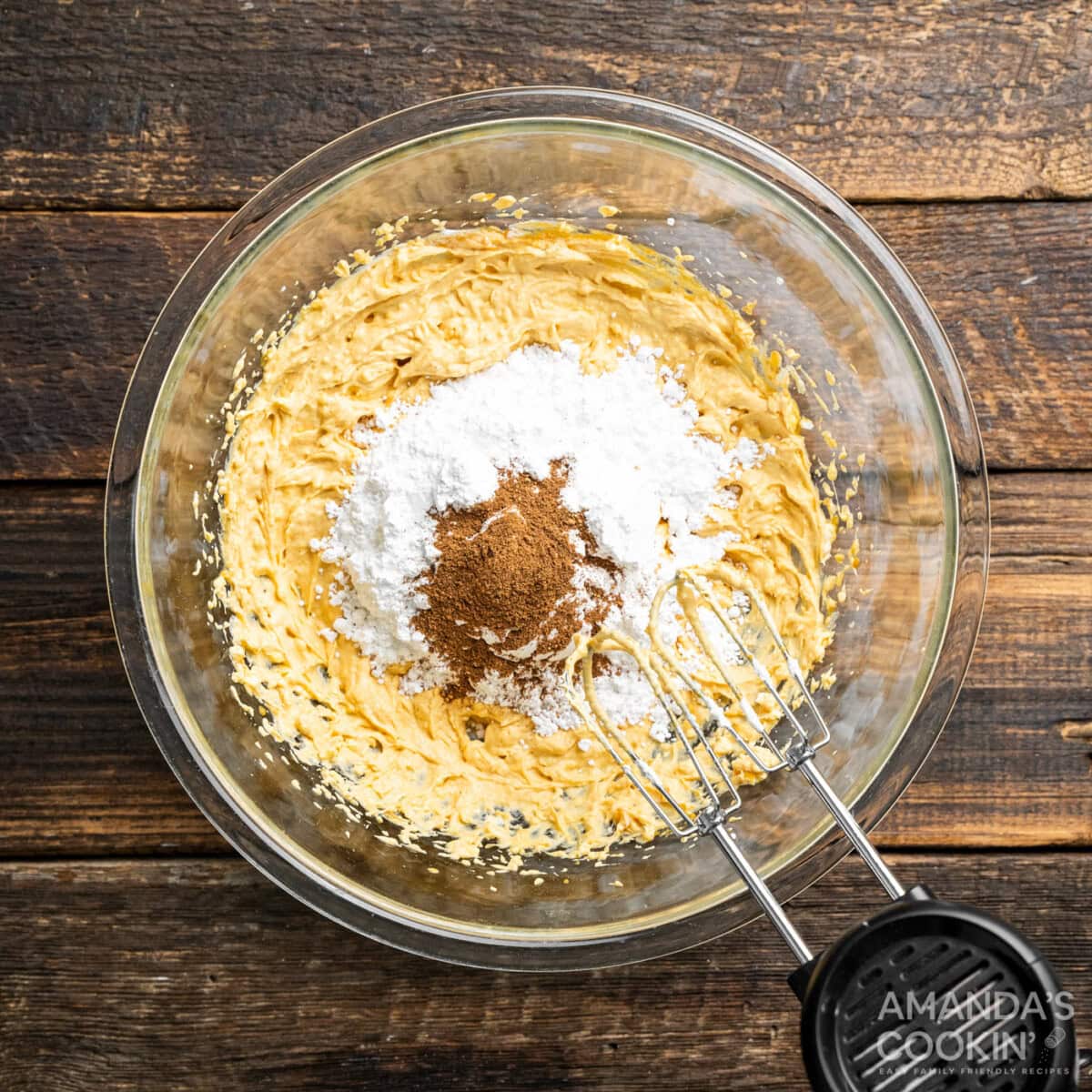 hand mixer beating pumpkin cream cheese with powdered sugar