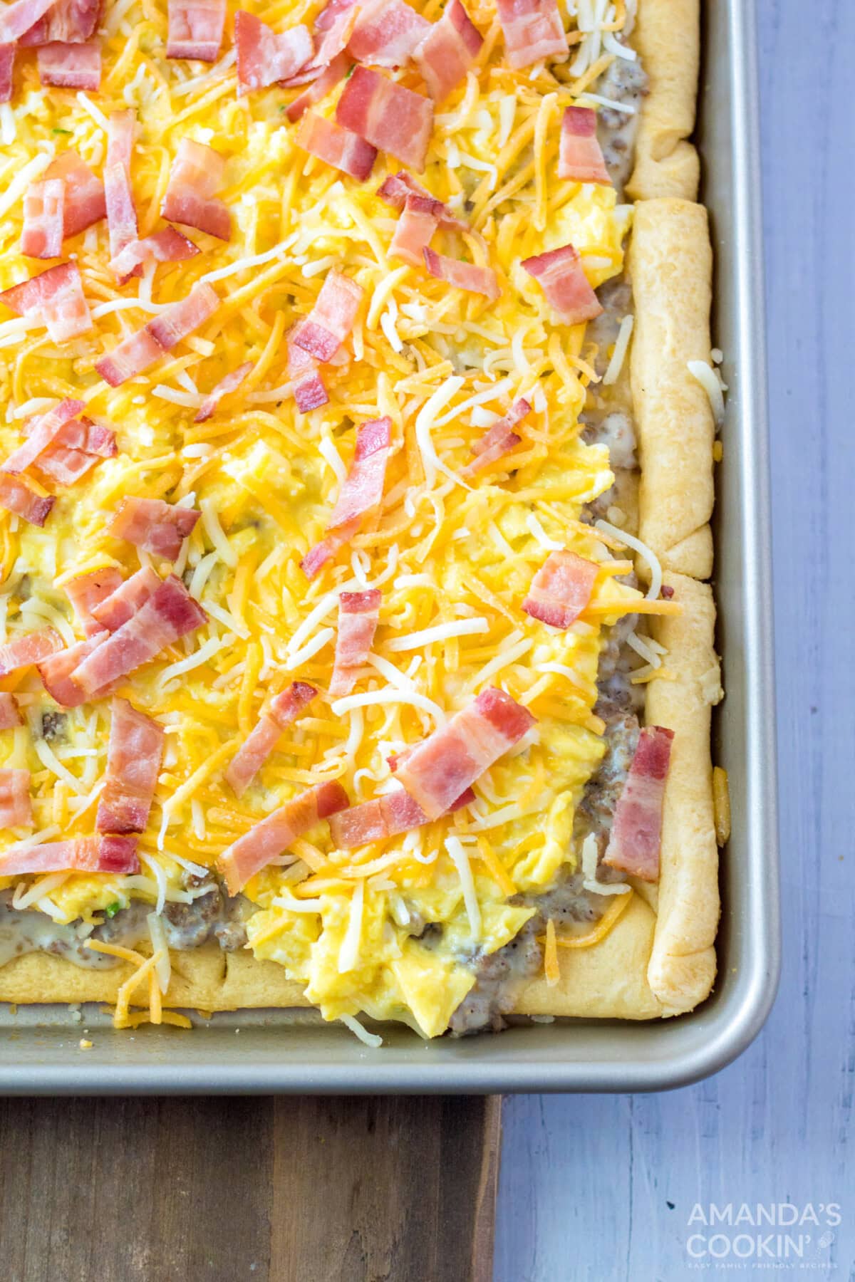 shredded cheese, egg, and sausage on top of crescent dough