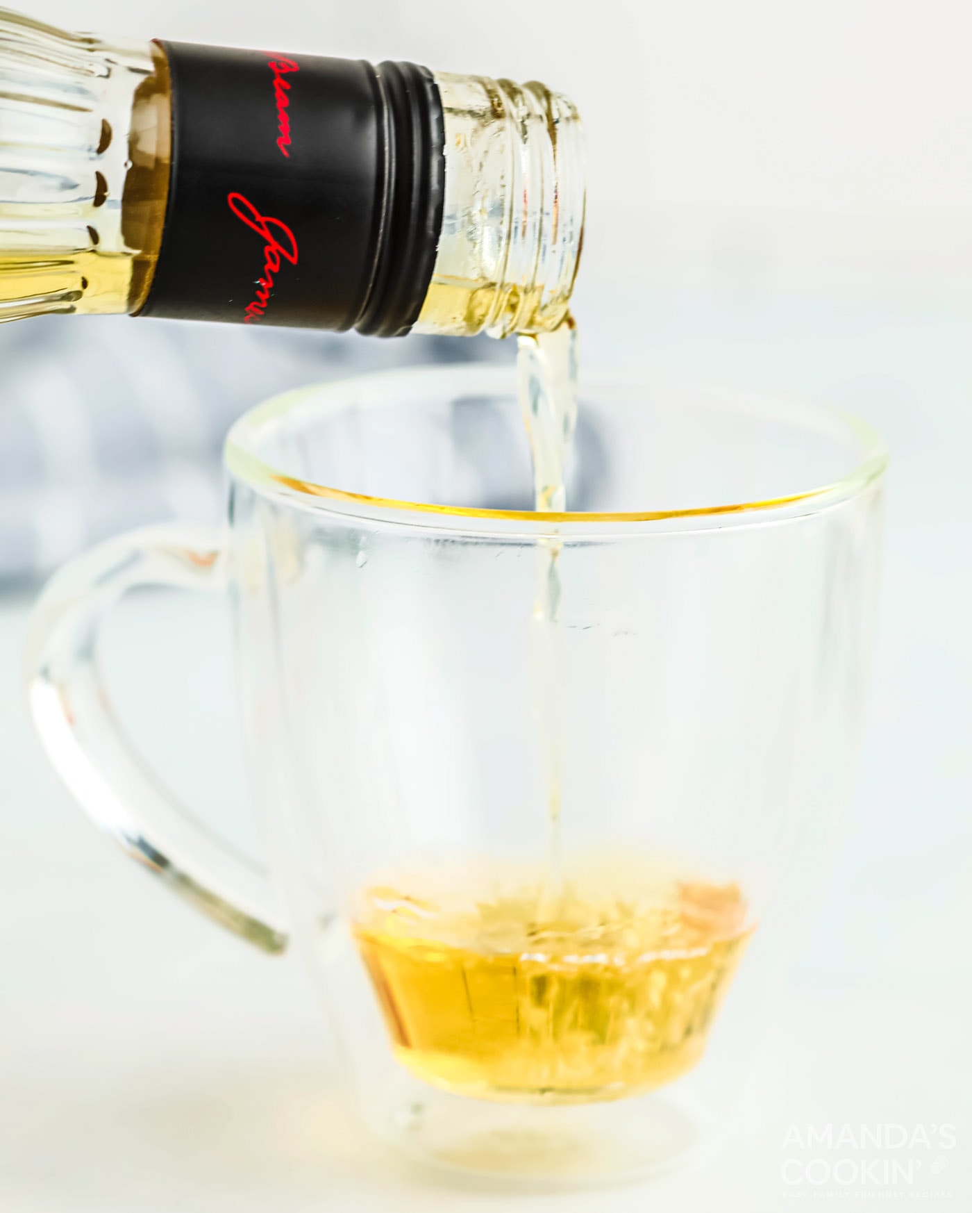 pouring apple whiskey into a mug
