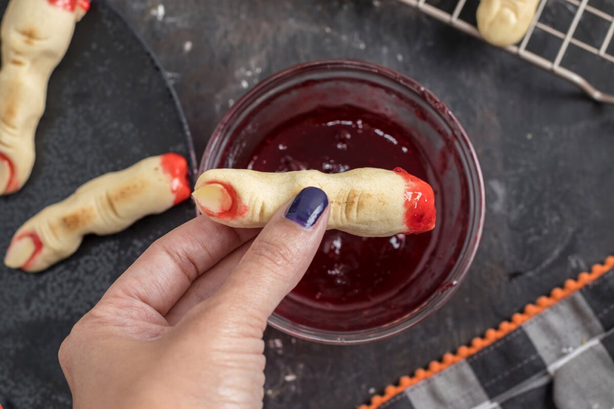 dipping witch finger cookies in jam