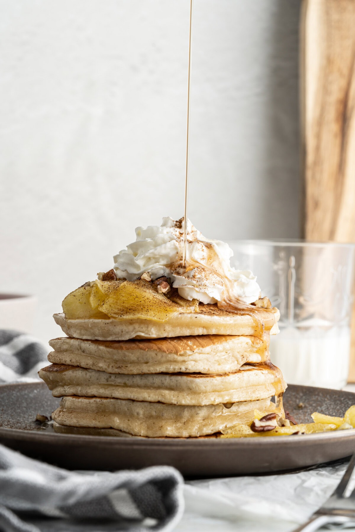 drizzling syrup onto apple pancakes