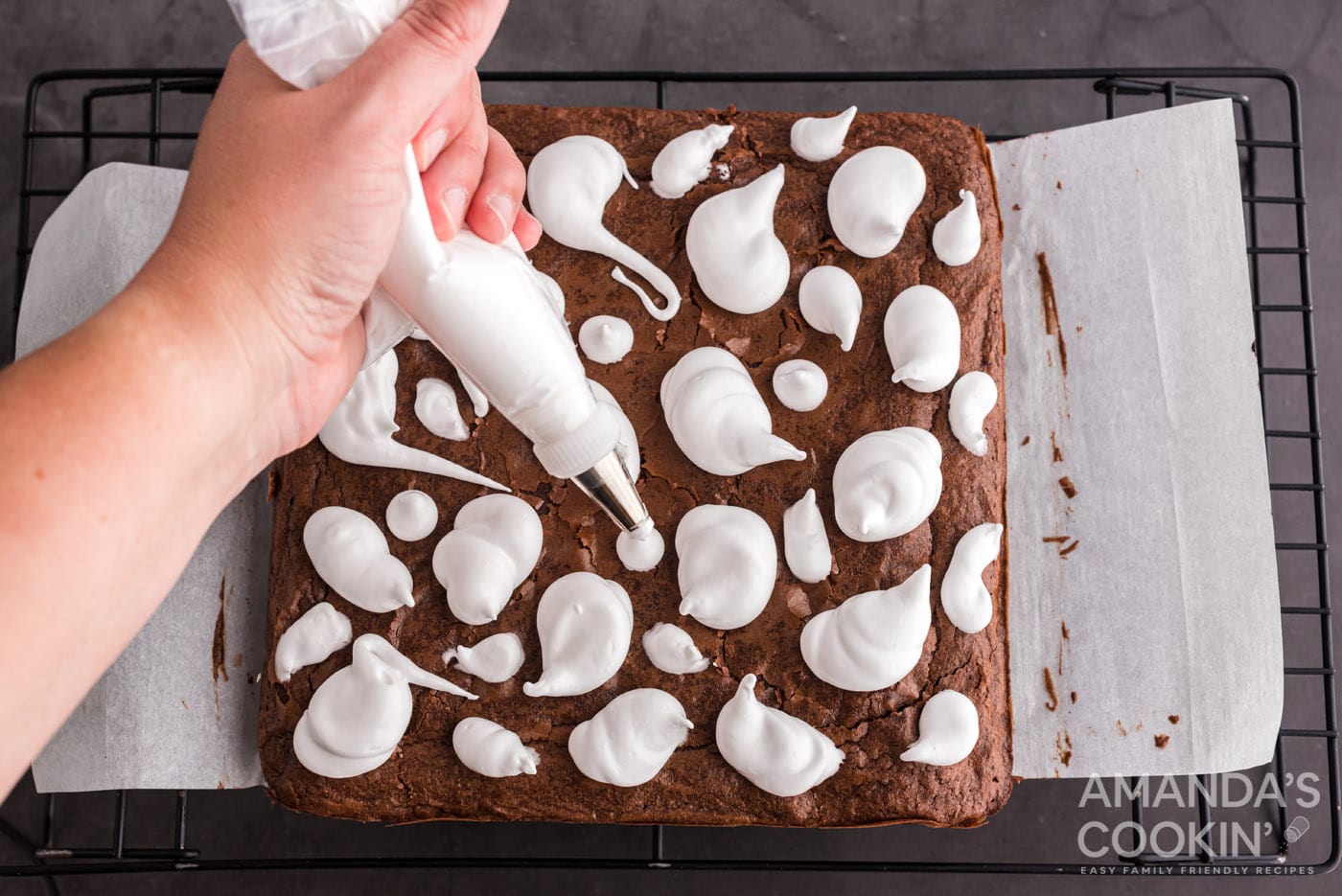 piping marshmallow ghosts onto brownies