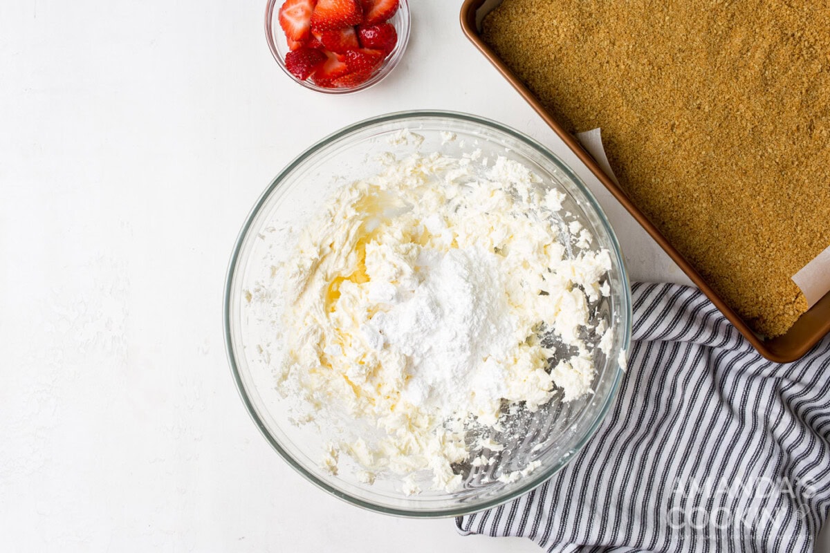 cream cheese with powdered sugar in a mixing bowl