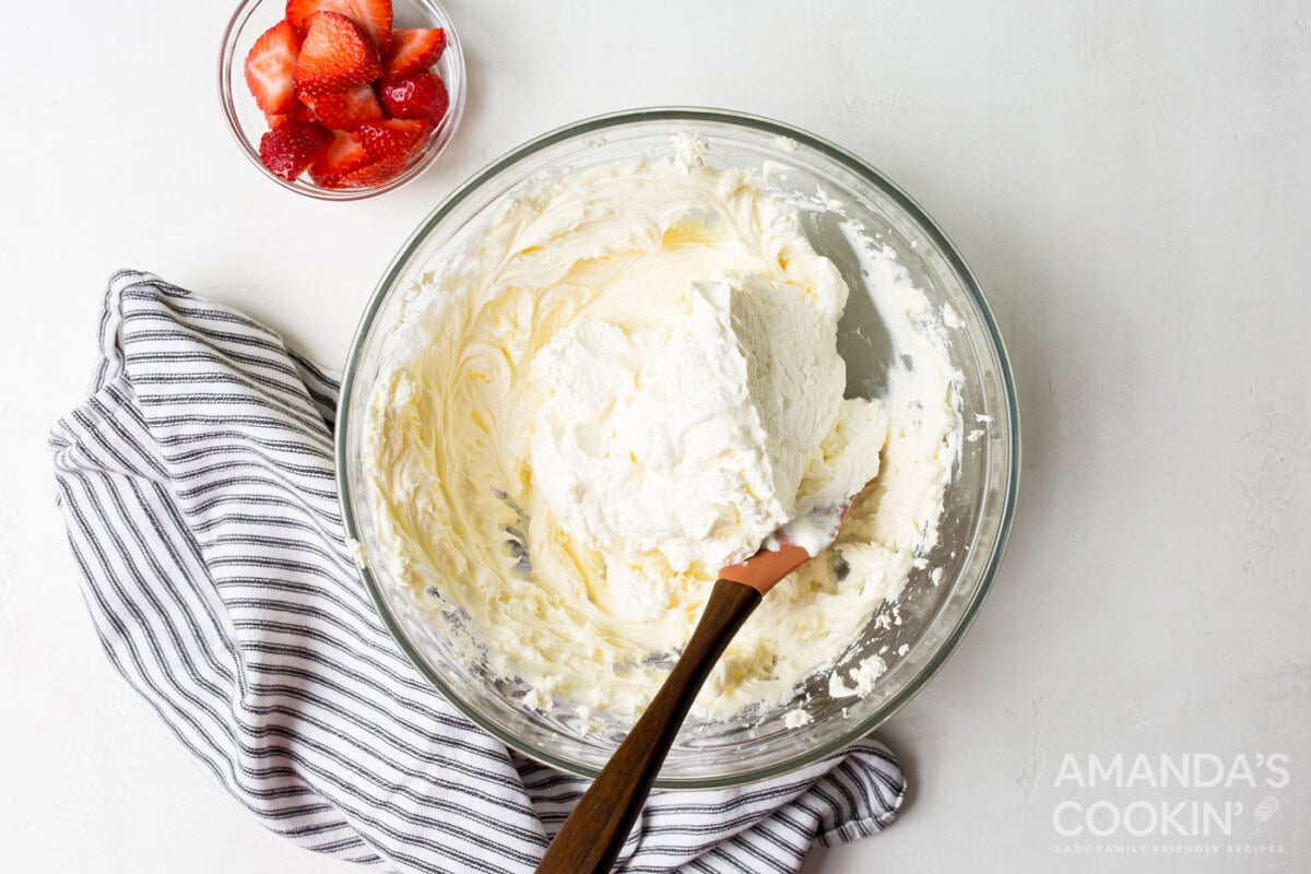 folding whipped cream into cheesecake mixture