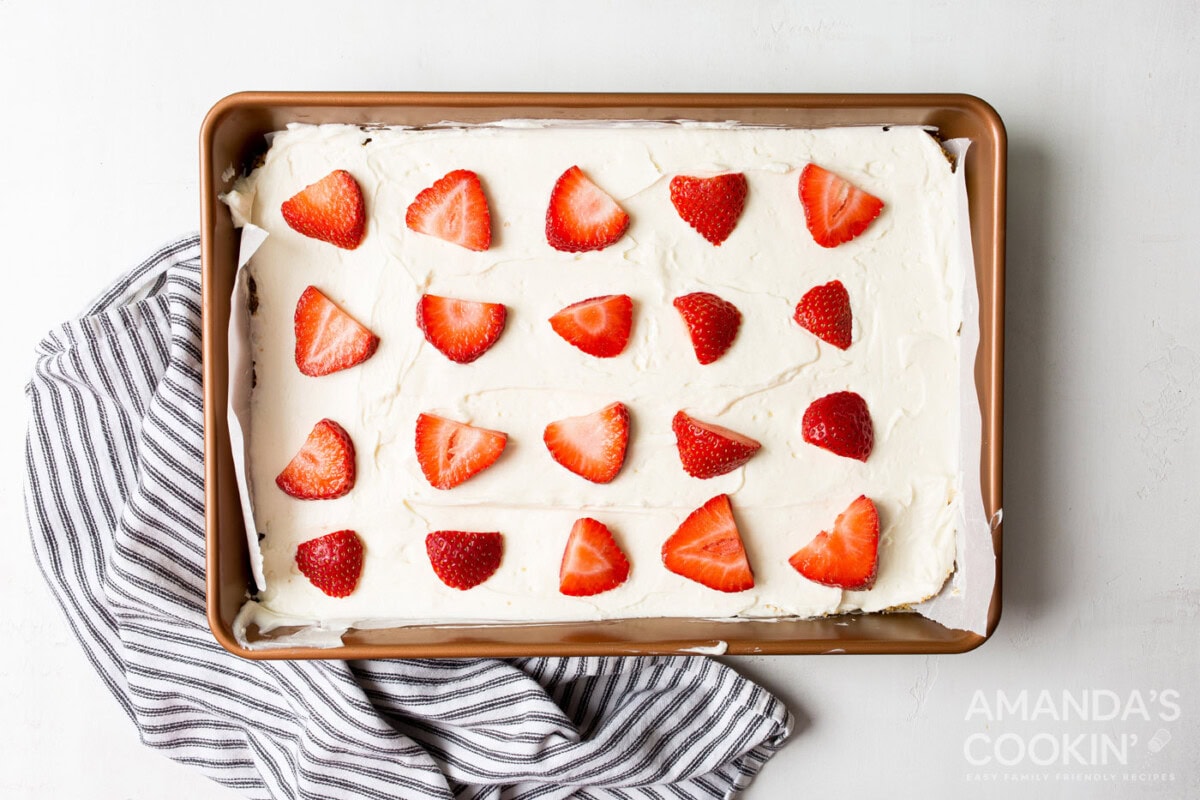 sliced strawberries on top of no bake cheesecake bars