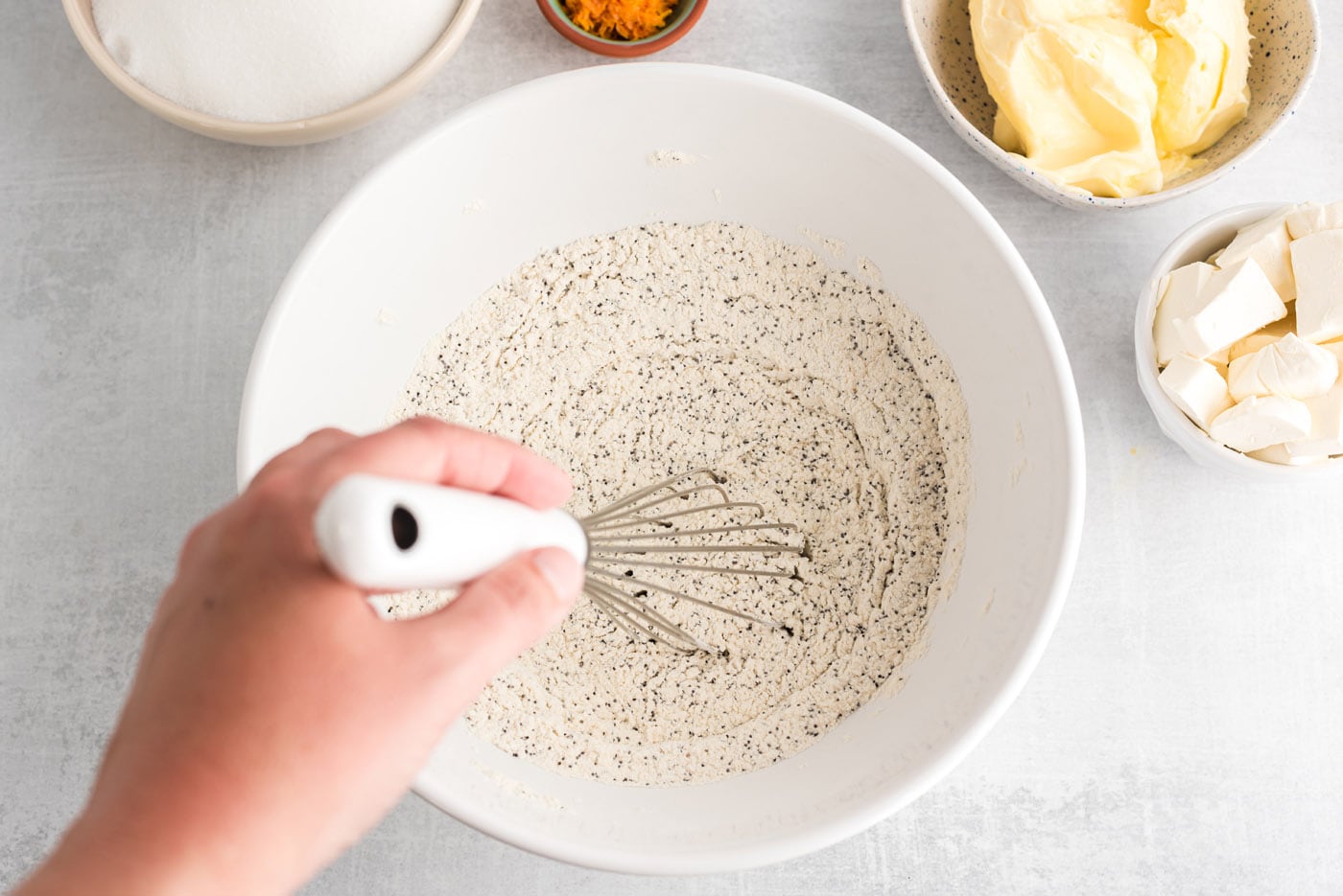 whisking together poppyseed, flour, salt, and baking powder in a bowl