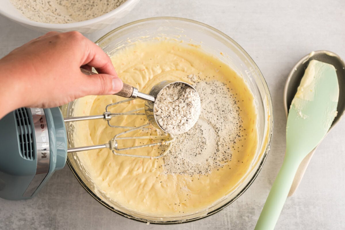 adding poppyseed flour mixture to batter