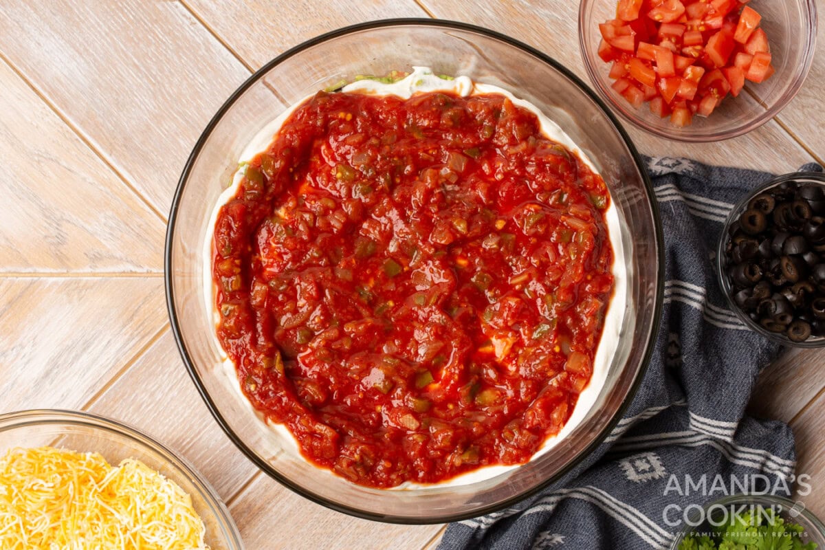 salsa on top of sour cream in a bowl