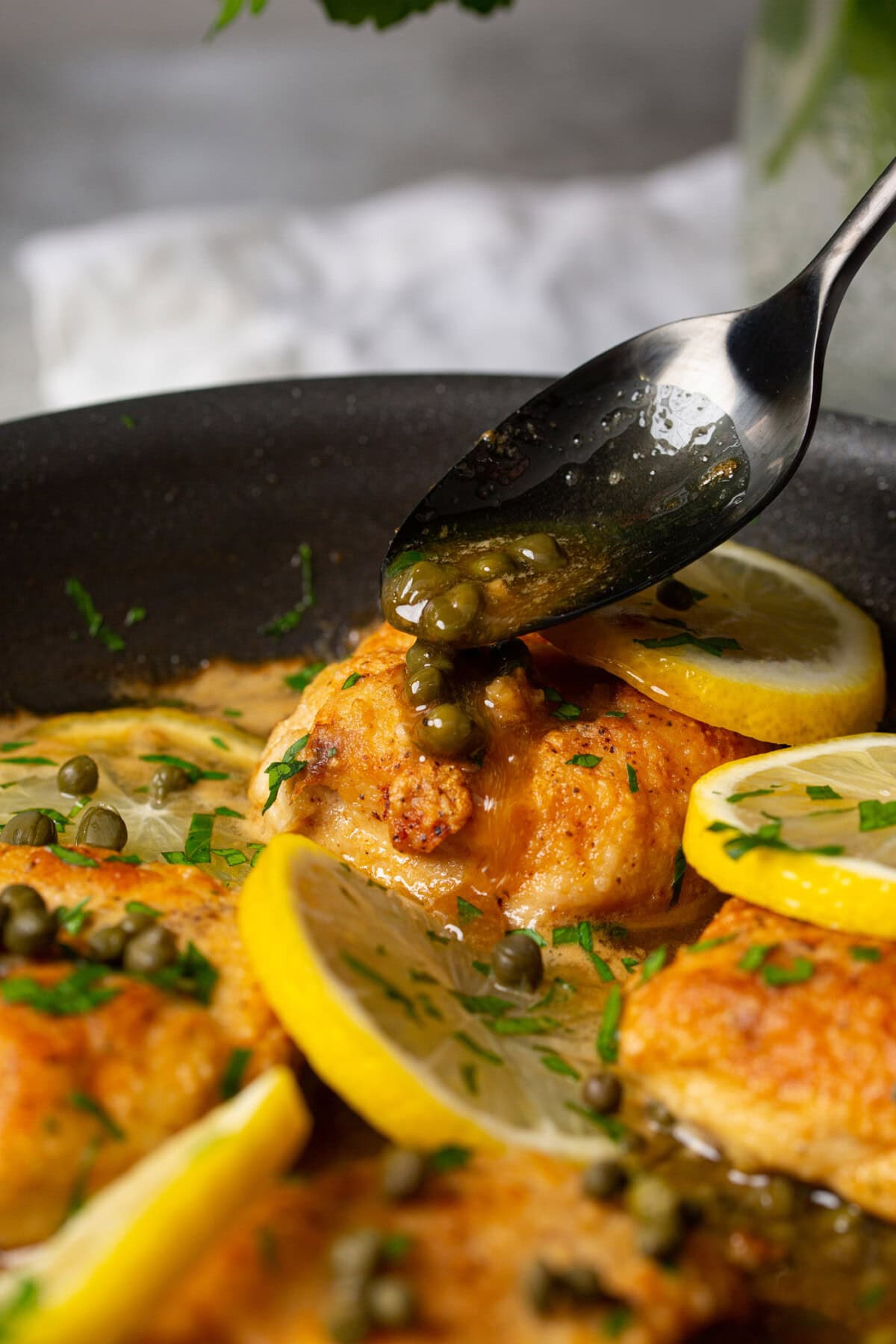 drizzling capers onto Chicken Piccata