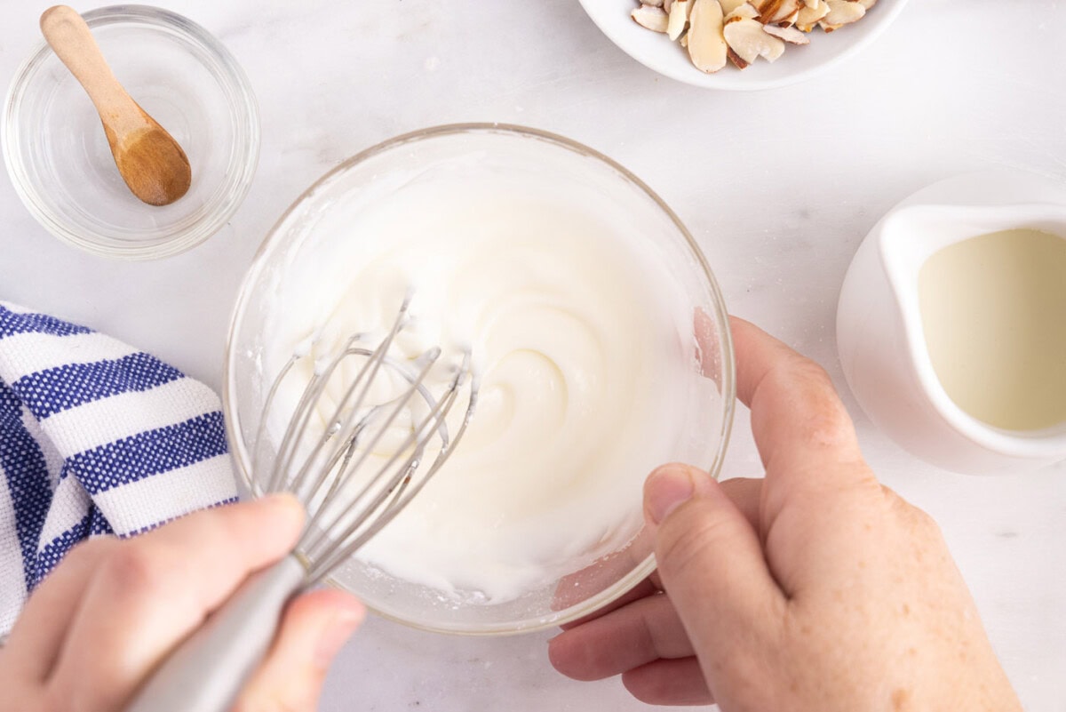 whisking powdered sugar and almond extract in a bowl