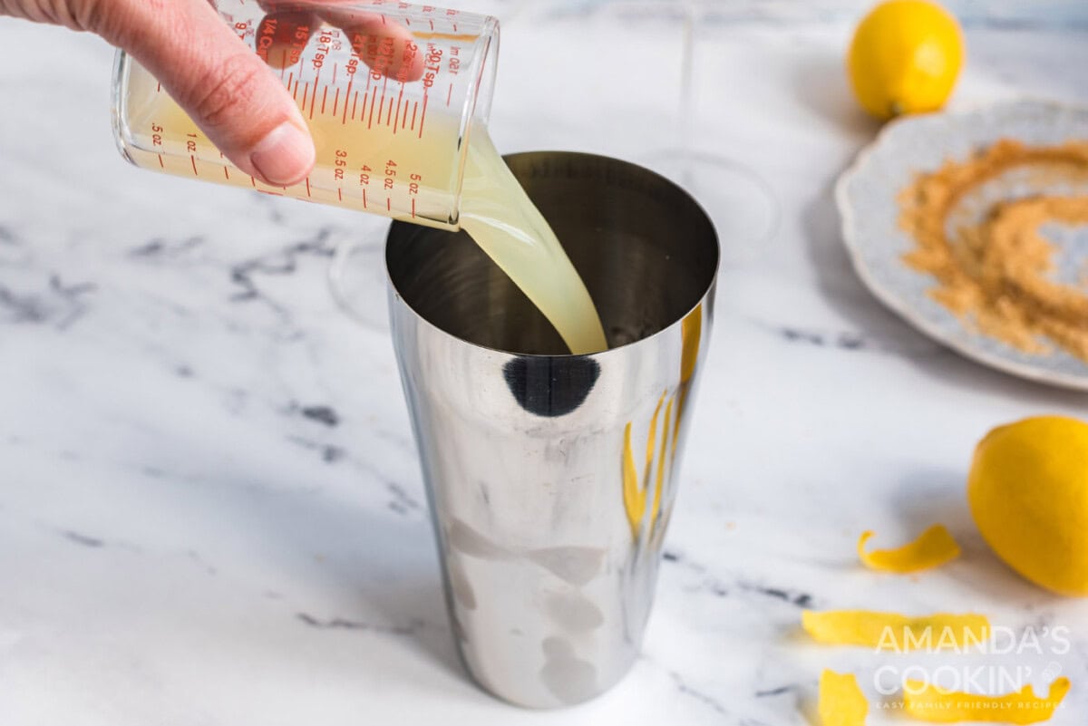 pouring lemon juice into cocktail shaker