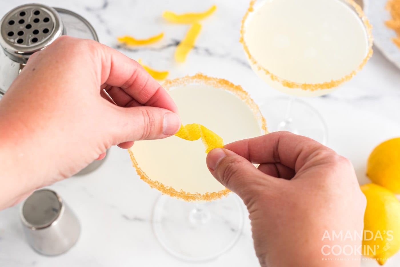 twisting lemon peel over cocktail
