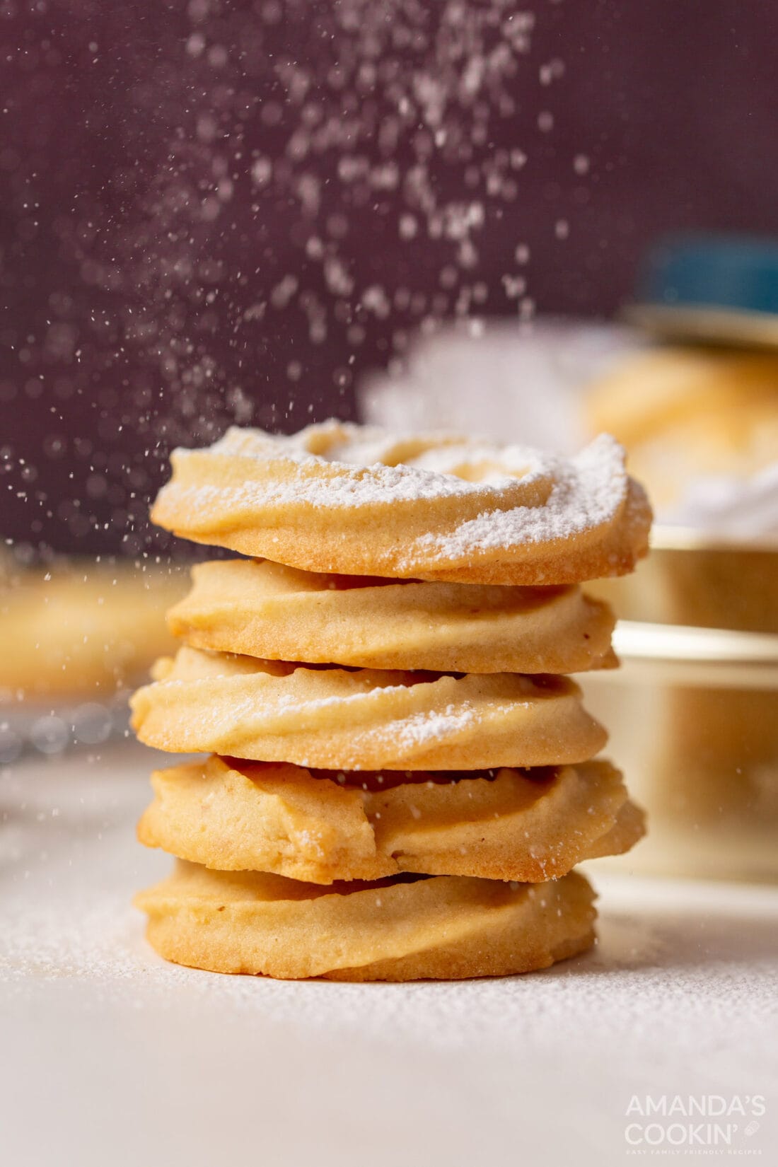 sprinkling powdered sugar on Swedish Butter Cookies