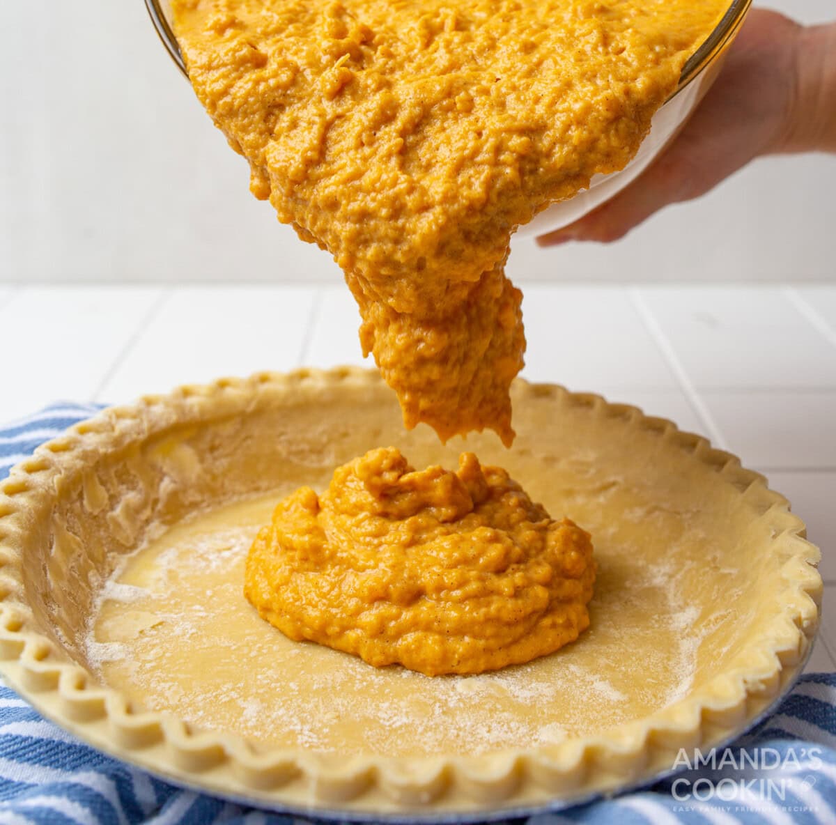 pouring sweet potato mixture into pie crust