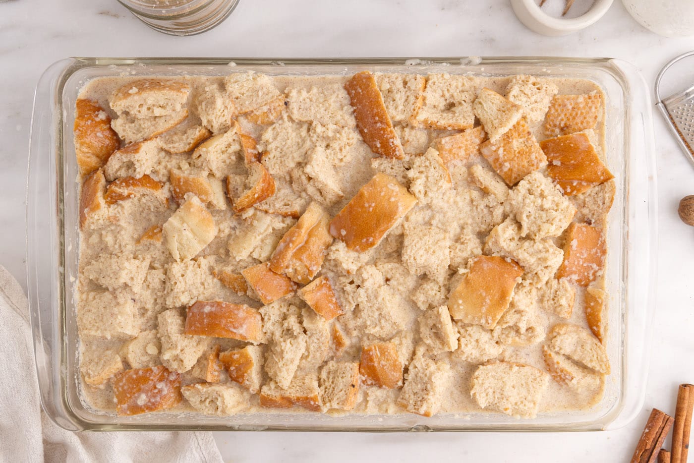 bread pudding soaking in a baking dish