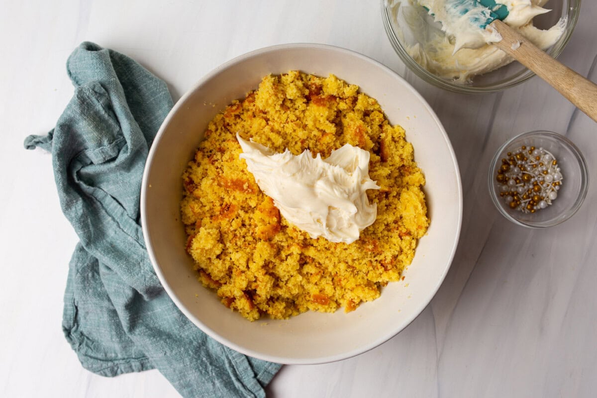 crumbled cake in a bowl with vanilla frosting