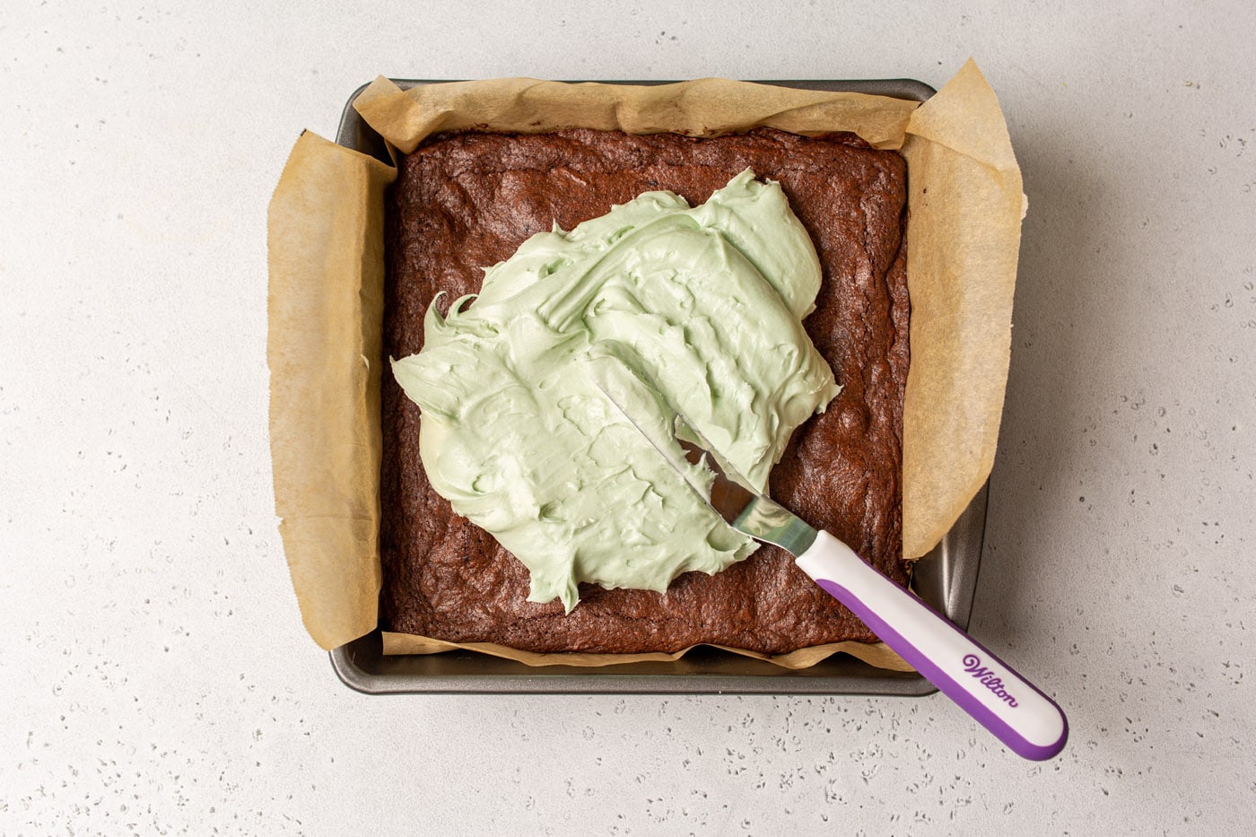 mint frosting spread onto brownies