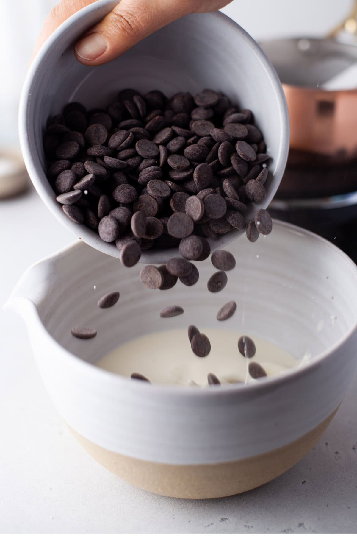 pouring chocolate chips into whipping cream