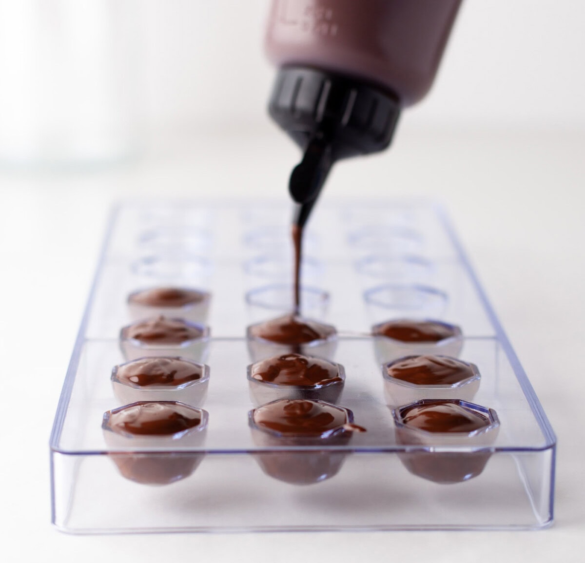 squeezing chocolate into candy mold