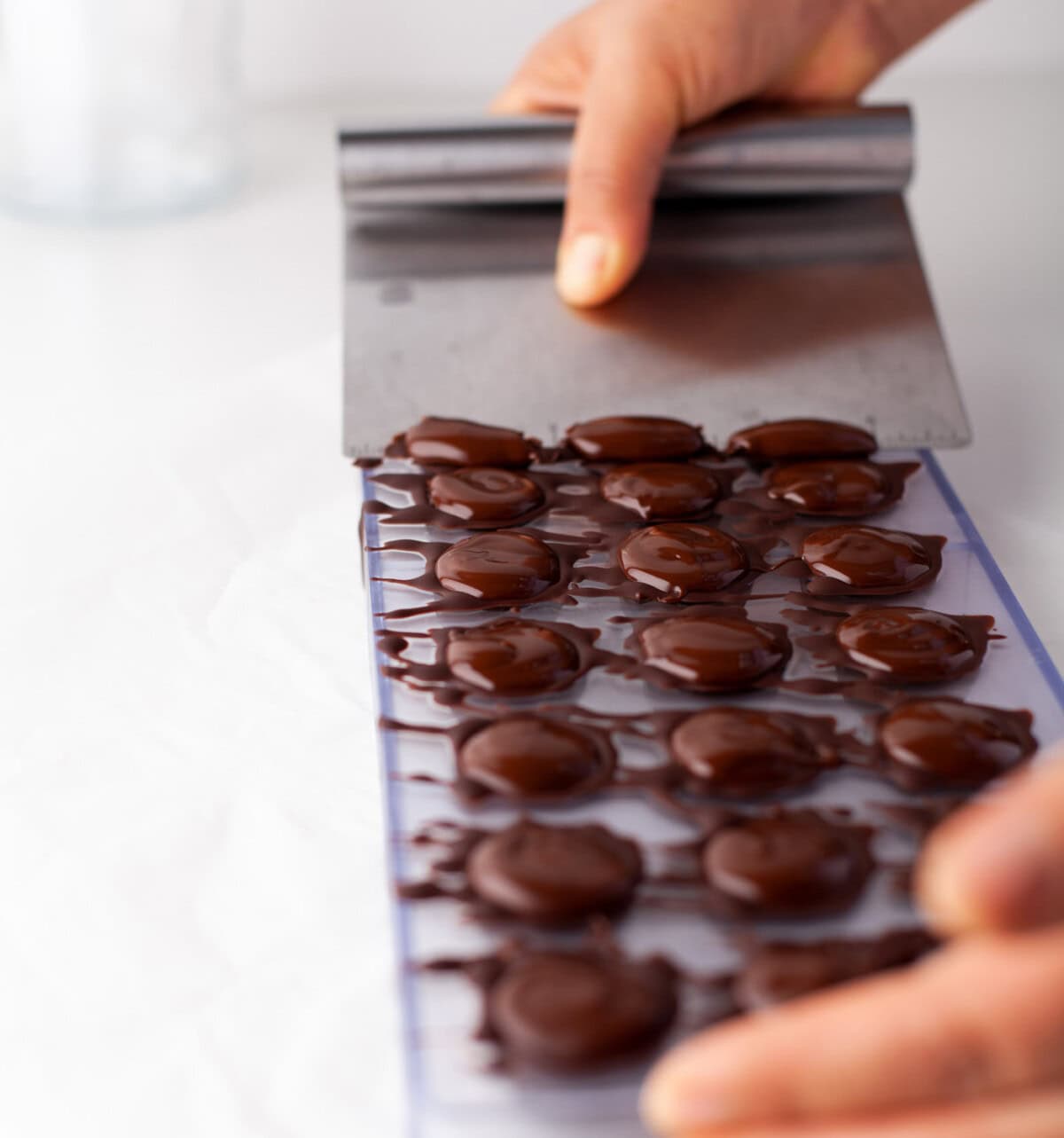 scraping chocolate off of candy mold