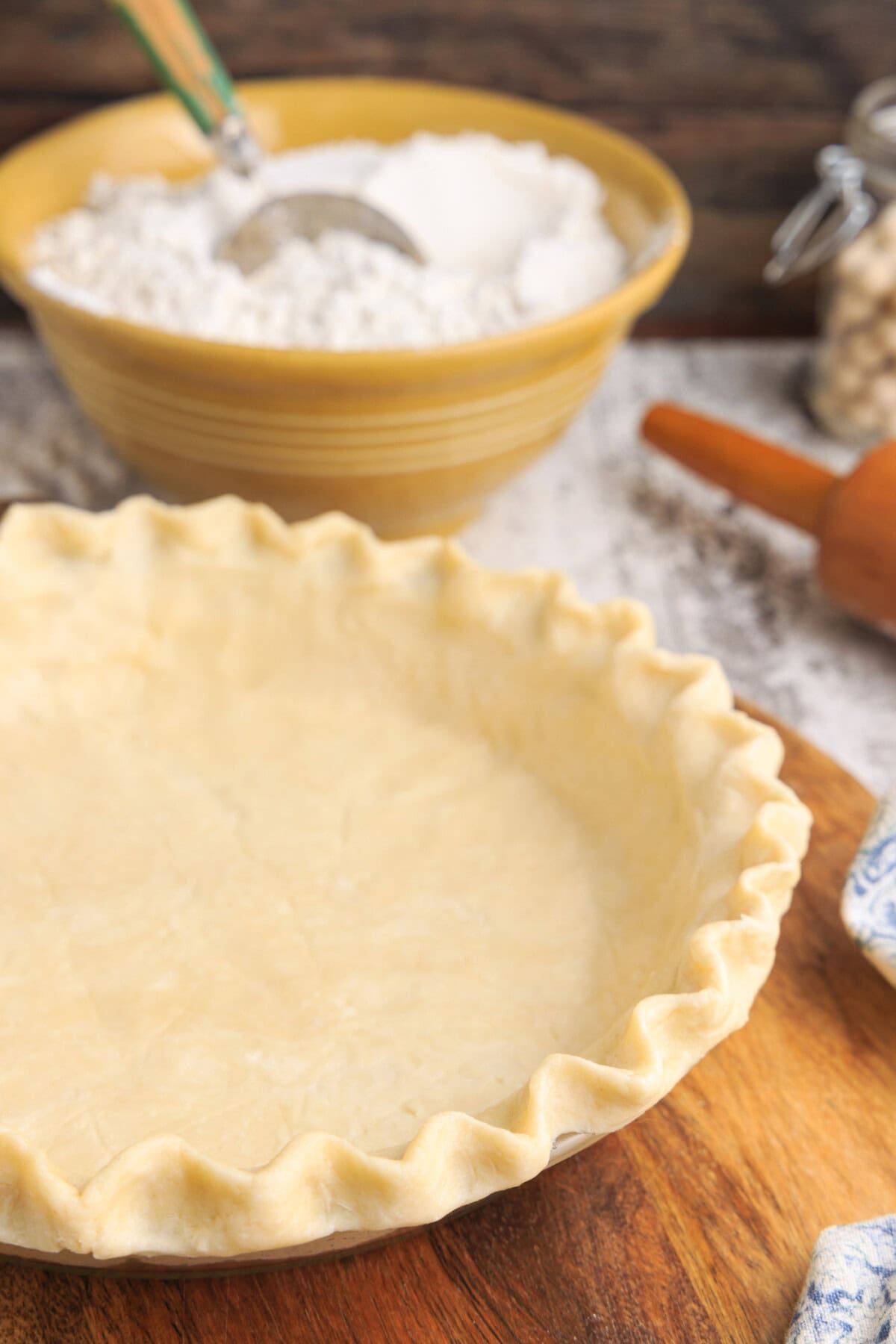 pie crust with bowl of flour in background