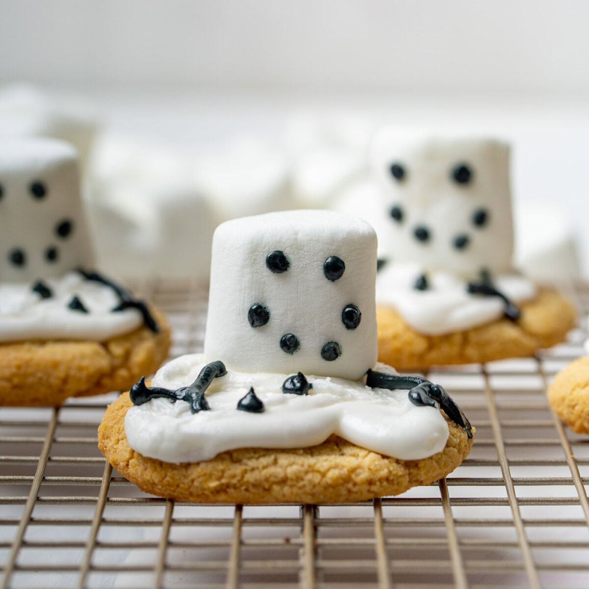 eyes, mouth, buttons, and arms made out of black icing