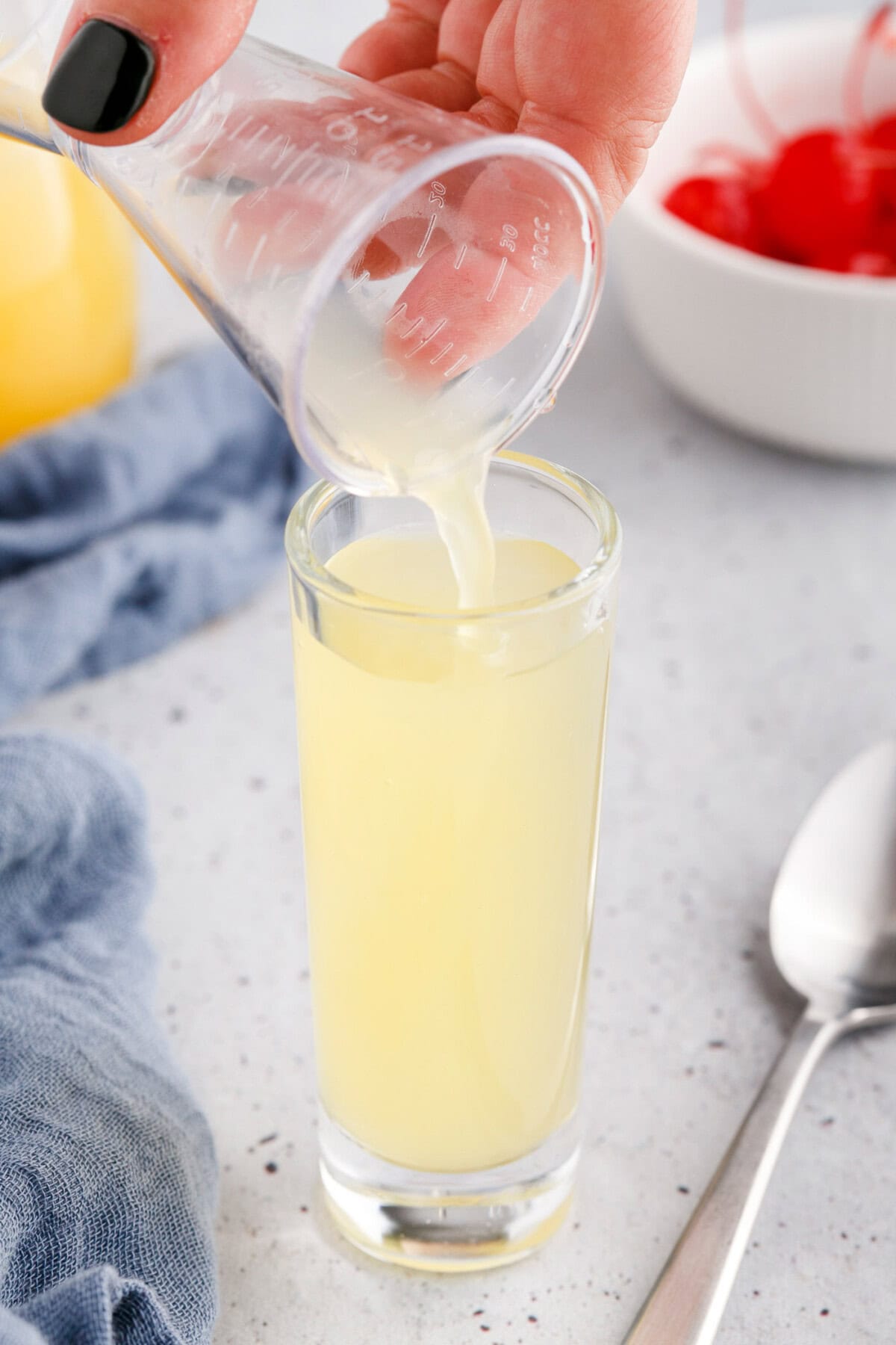 pouring pineapple juice to a shot glass