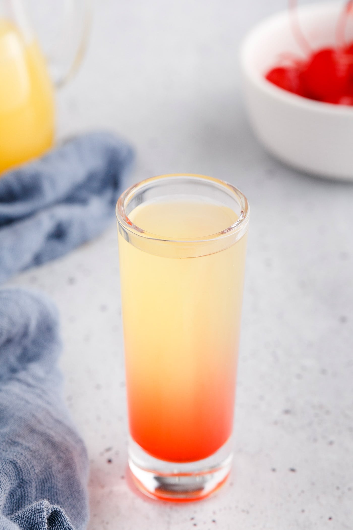 shot glass with grenadine, pineapple juice, and vodka