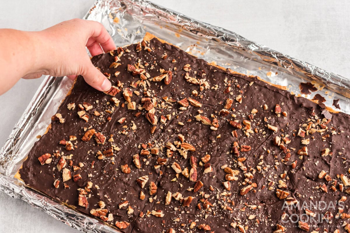 hand breaking off a piece of saltine toffee