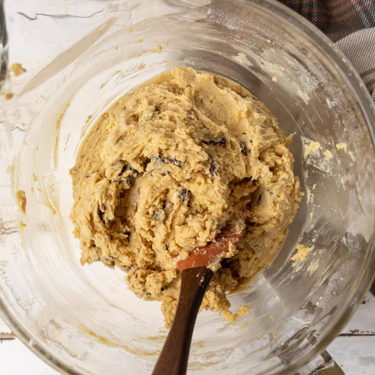 wooden spoon stirring oatmeal raisin cookie dough