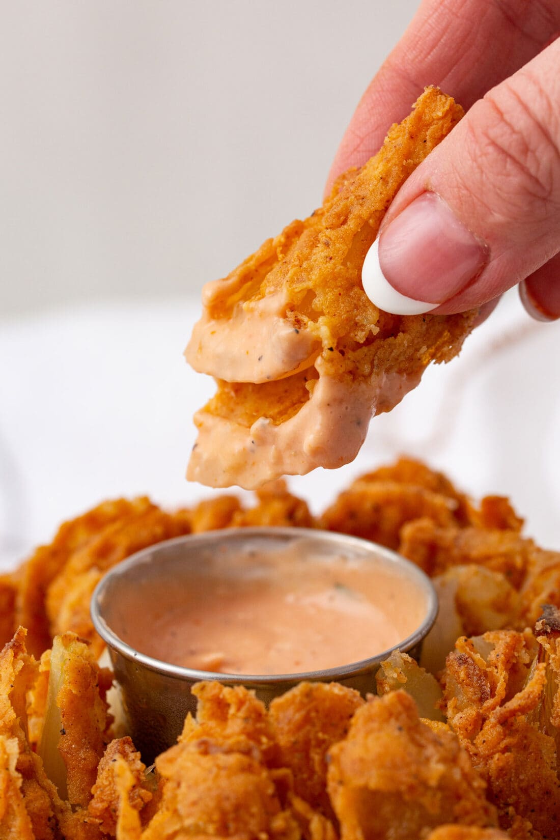 dipping a piece of Blooming Onion