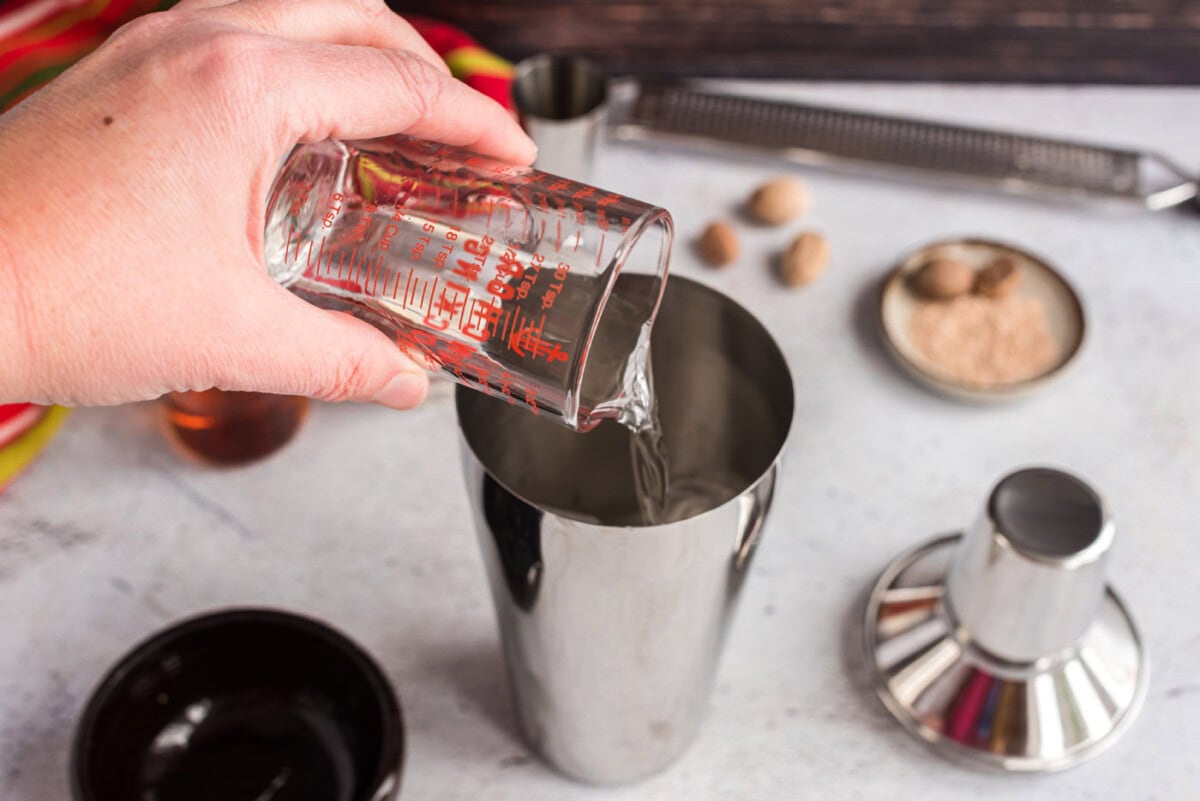 pouring creme de cacao into cocktail shaker