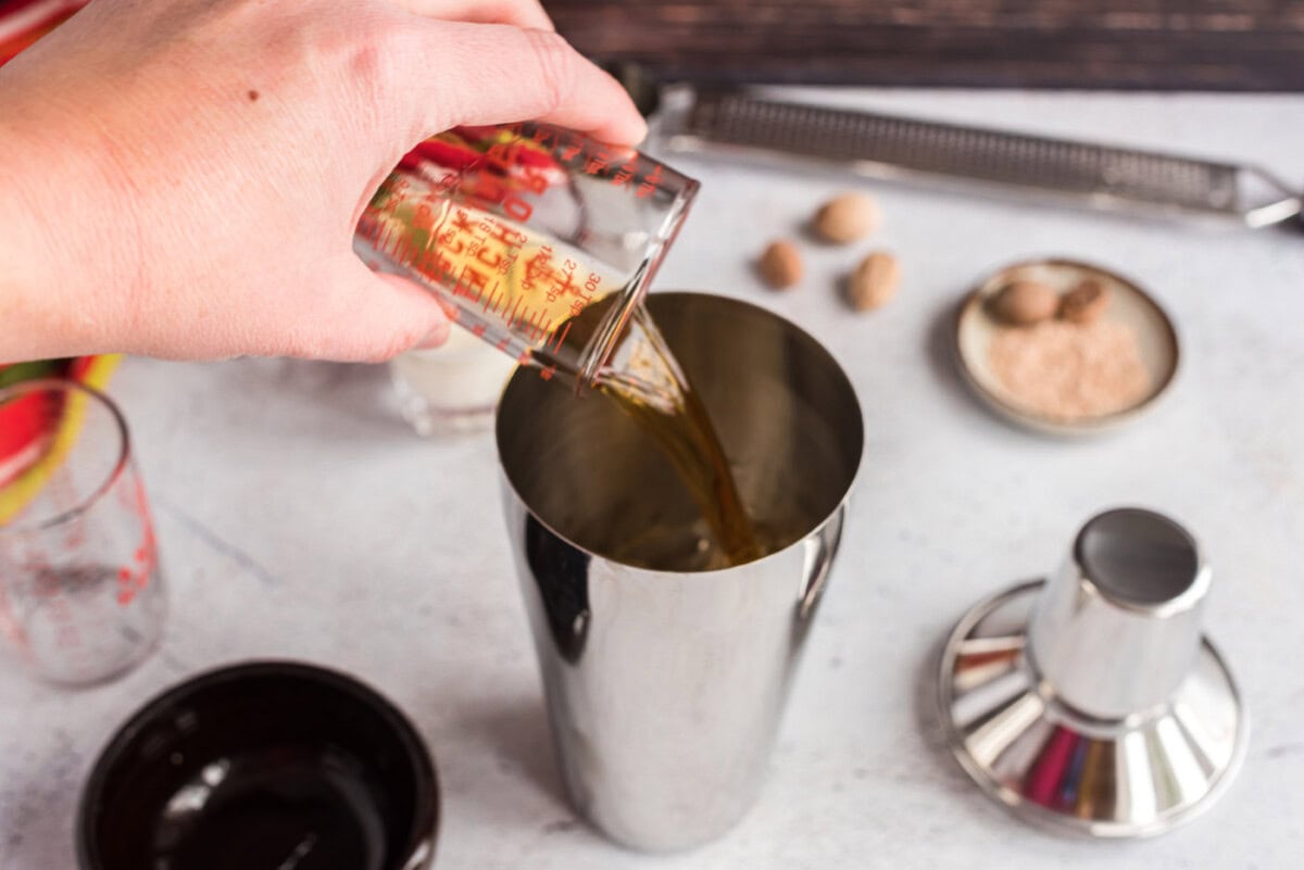 pouring brandy into cocktail shaker