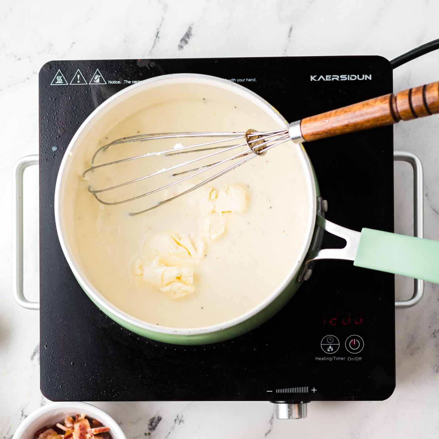 stirring cream cheese into saucepan